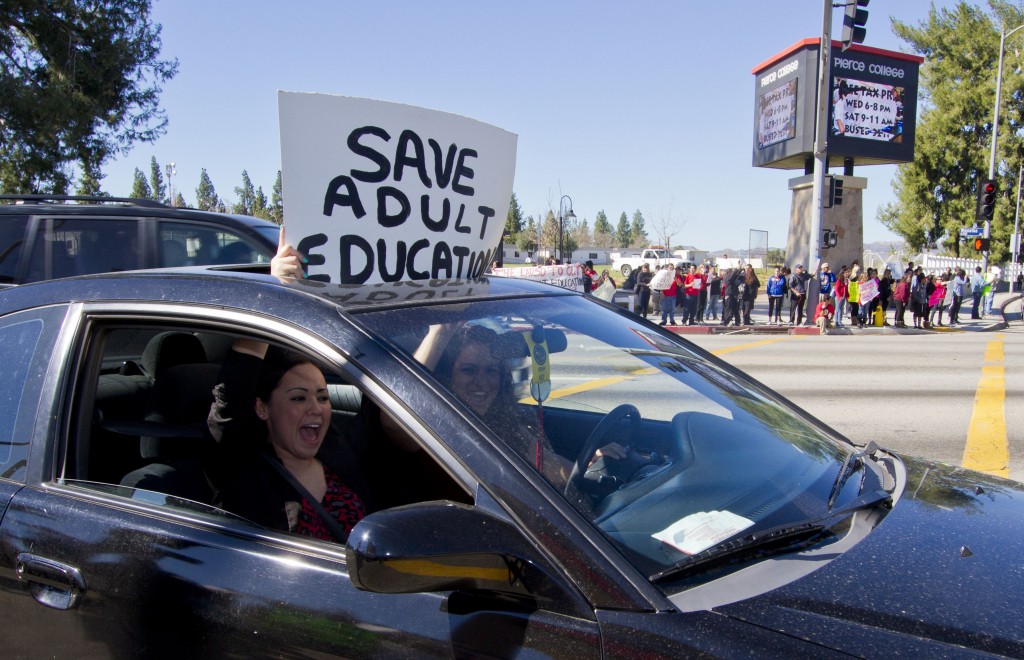 Two protesters drive by the protest of the potential shutdown of adult schools held at the corner of Victory Blvd and Winnetka Ave Wednesday Feb. 8, 2012. Photo: Jose Romero