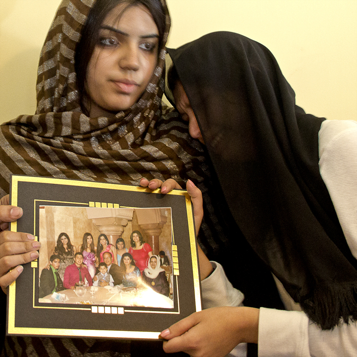 On Friday April 13, 2012, Michelle Arian (left), and Nelofar Arian (right) hold up a family portrait including Abdul Arian who is seen wearing a red dress shirt, just two days after Abdul was shot and killed by LAPD during a pursuit which ended on the 101 North-bound after running a red light and continuing to drive erratically. Photo: Kristen Aslanian