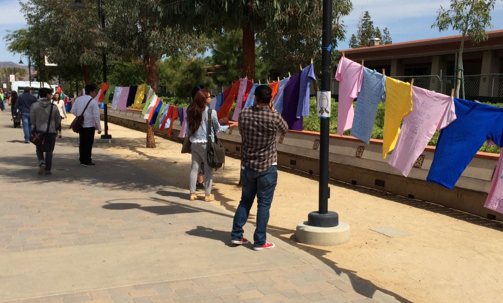 Personal messages of sexual crimes against women written on T-shirts hang along The Mall during the Clothesline Project. Photo: Richard Zamora