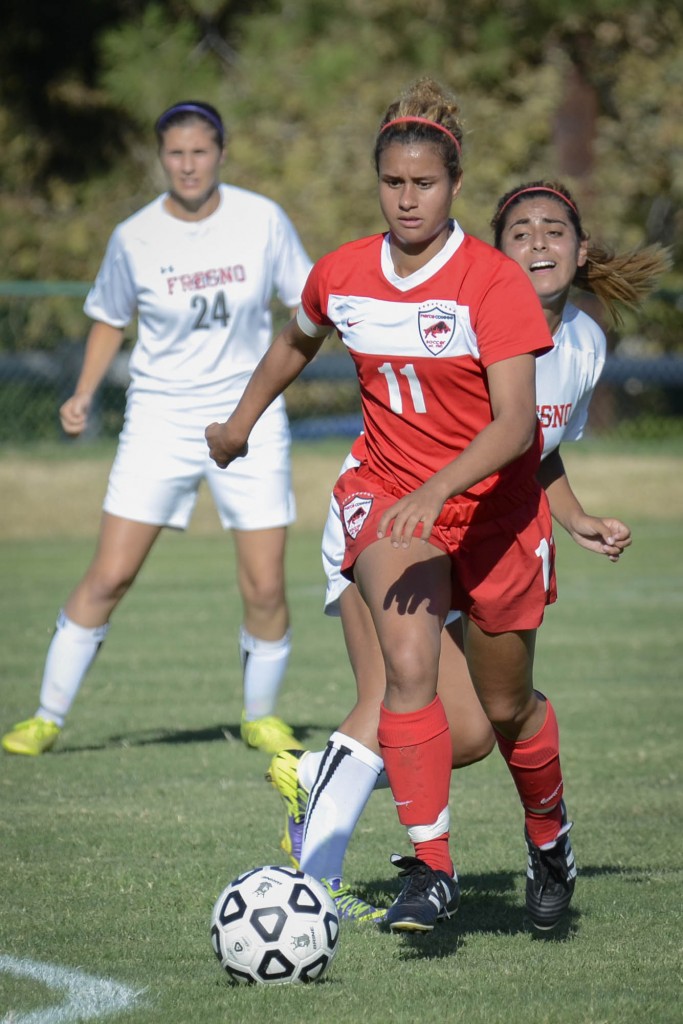 Forward for Pierce College, Paige Wolny dribbles passed defender Kat Garcia from Fresno City College. Photo by: Stacy Soriano