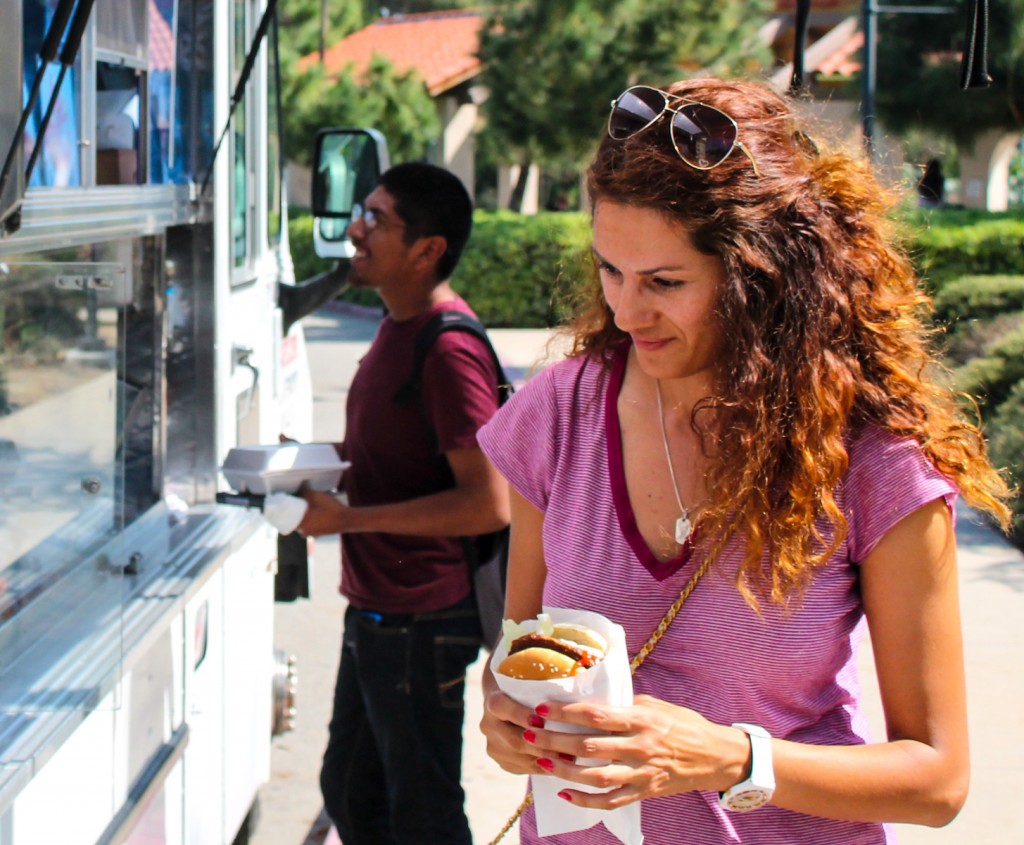 Leylaman Mams a inteior design major about to eat hamburger while a students places an order. Parking lot 1 at the Hot Coffee Catering truck at Pierce College Woodland Hills Calif. Monday, March 19, 2015. Photo By Tim Daoud