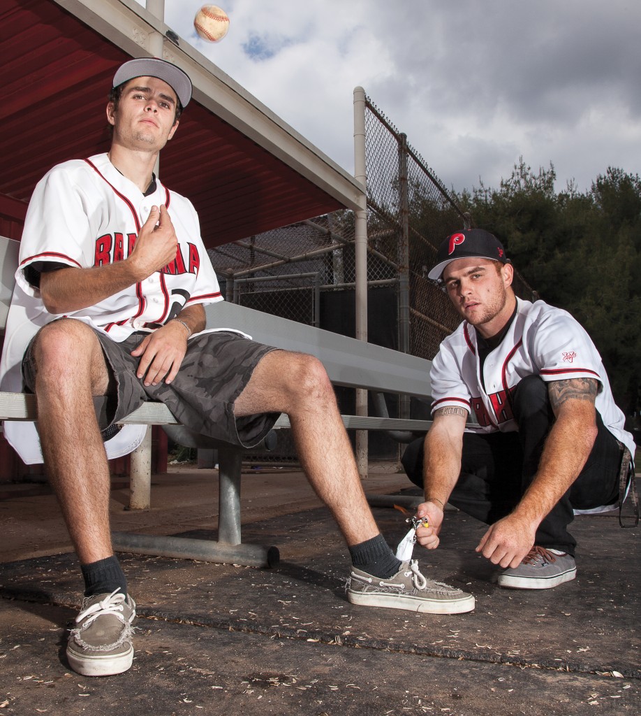 Jason Rowe tosses a baseball while Matt Rowe tries to light his foot on fire in this portrait recreating a typical prank done by baseball players on Monday, May 18 at the home dugout of Joe Kelly Field. Photo by: Mohammad Djauhari