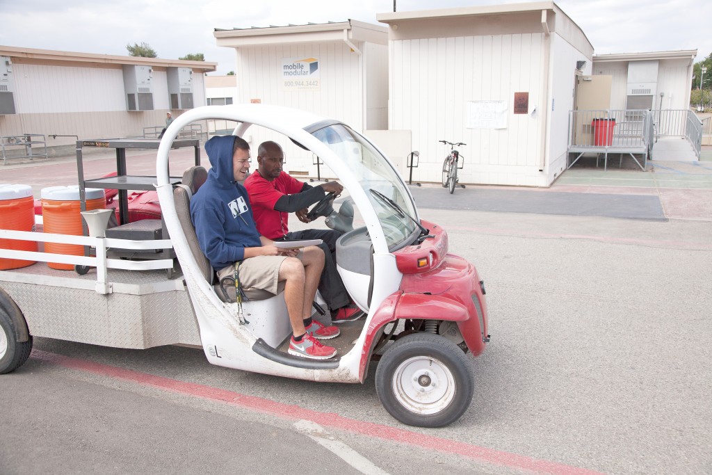 Defensive coach Torry Hughes drives one of the carts used by the athletic department. Under new district policy, authorized drivers are prohibited from having passengers except under certain conditions. Photo: Mohammad Djauhari