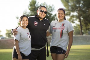 Alexis Lopez (left) and Alejandra Carvajal (right) pose with assistant coach Willie Diaz on the soccer field at Pierce College in Woodland Hills, Calif. on Oct. 24, 2016. Photo by Taylor Arthur 