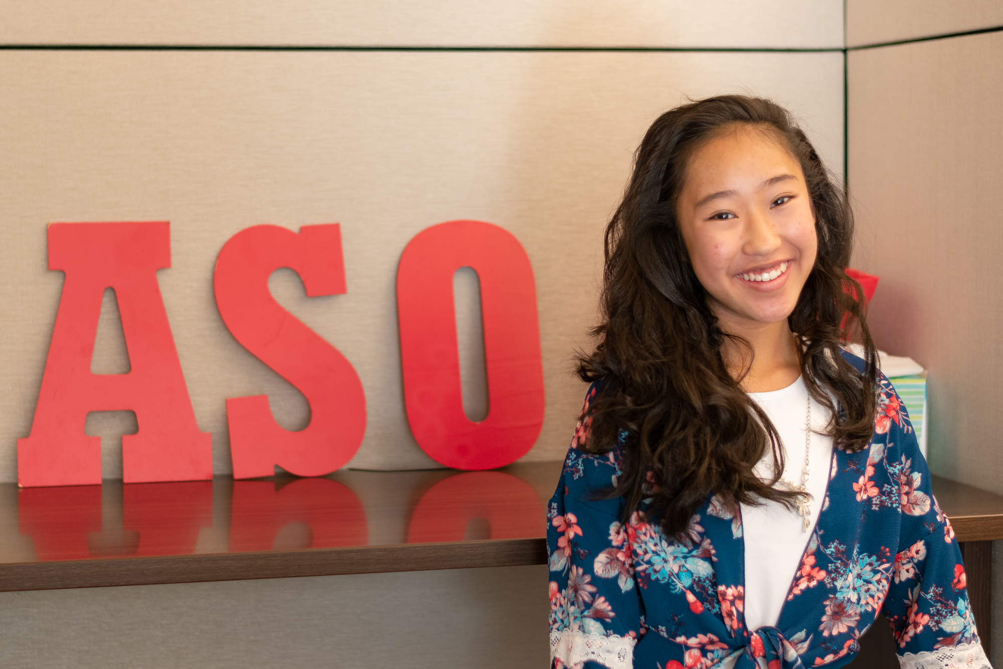 Vivian Yee stands in front of ASO sign